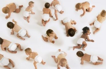 A group of babies crawling on a white floor