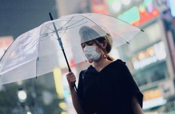 Woman holding a transparent umbrella. Shibuya Crossing, Tokyo, Japan.