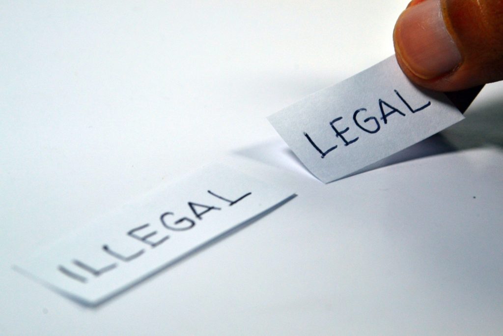 Two strips of paper: One says "legal," the other "illegal."